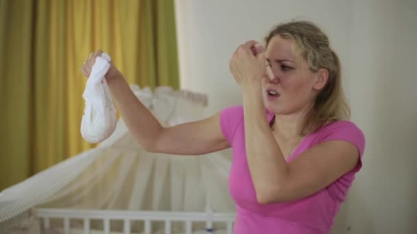 Eine Frau wechselt eine schmutzige Babywindel. junge Mutter. — Stockvideo