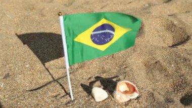 Kumlu bir plaj üzerinde Brezilya bayrağı.