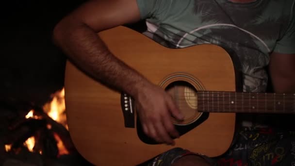 Un uomo suona la chitarra sullo sfondo di un incendio . — Video Stock