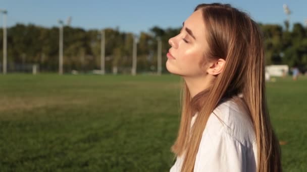 Gyönyörű fiatal nő a parkban. — Stock videók