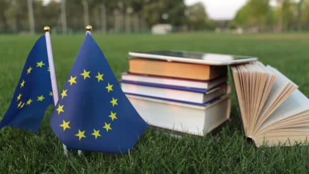 Flaga Unii Europejskiej i książek na trawie. Edukacja w Europie. — Wideo stockowe