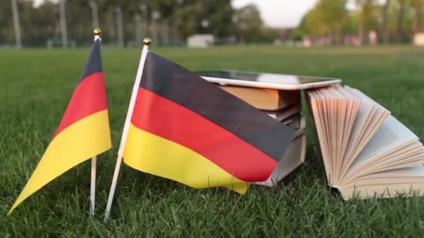 Німецька мова та освіти. Прапор Німеччини та книг на траві. — стокове відео