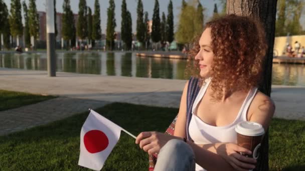 Hermosa turista femenina con la bandera de Japón . — Vídeos de Stock