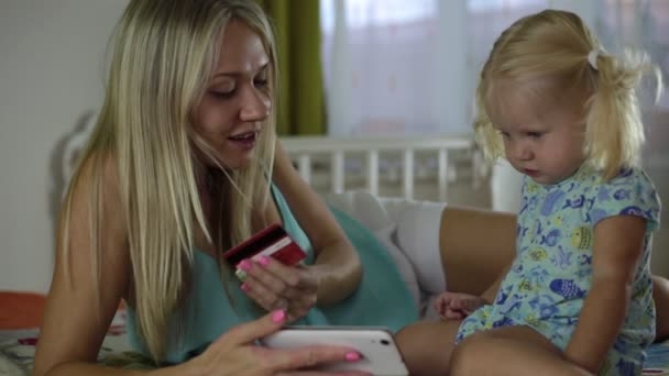 Woman and child with a bank card and smartphone. — Stock Video