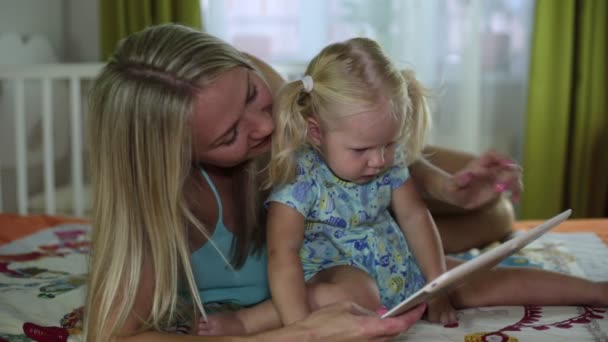 Mulher e criança com um tablet no quarto . — Vídeo de Stock