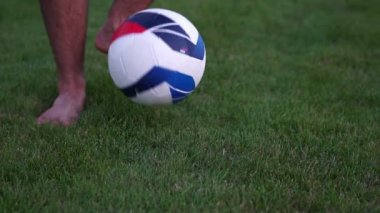 Futbol topu ve yeşil çim. Adam bir futbol topu, yavaş hareket ile.