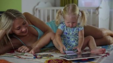 Smartphone ve çocuk evde tablet ile olan kadın. Becerikli alet ile aile.
