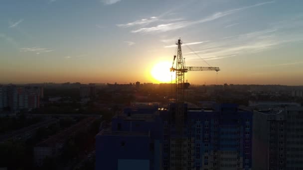Grue de construction sur fond de coucher de soleil — Video