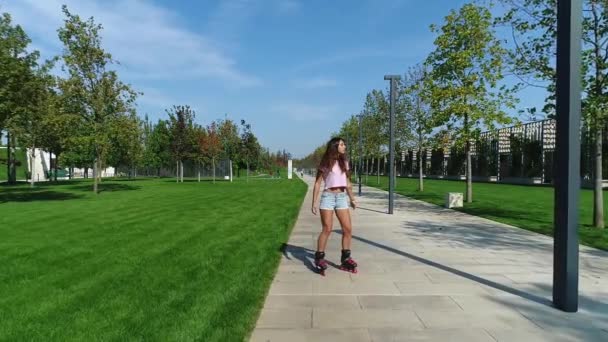 Молодая сексуальная женщина в шортах на роликовых коньках в парке . — стоковое видео
