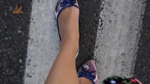 一个女人沿着马路走。在沥青背景的女性腿特写镜头. — 图库视频影像