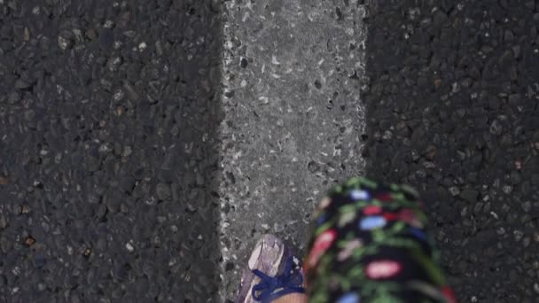 Frauenbeine in Großaufnahme auf Asphalt-Hintergrund. eine Frau läuft die Straße entlang. — Stockvideo