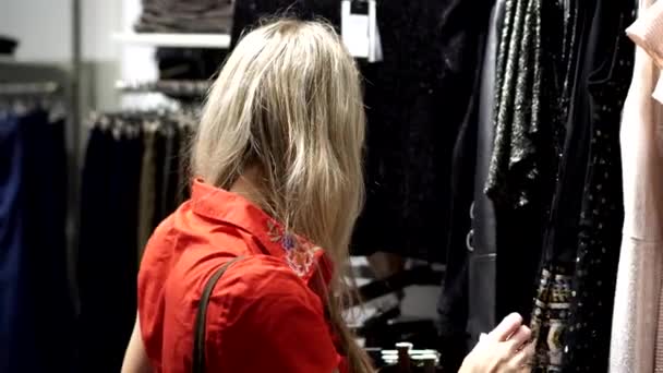 Молодая женщина в магазине одежды. — стоковое видео