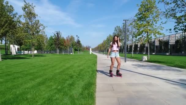 Junge Rollschuhläuferin im Park. schöne Mädchen Rollerblading. — Stockvideo