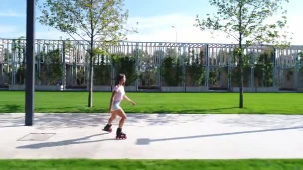 Mulher bonita está patinando no parque. Menina nos rolos . — Vídeo de Stock