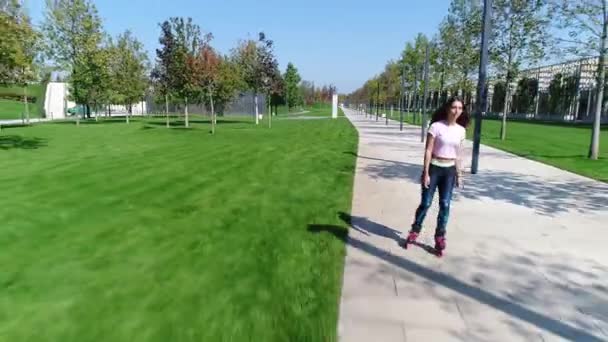 Mooie jonge vrouw is skaten in het park. — Stockvideo