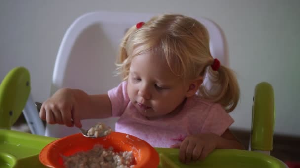 Ребенок ест за столом . — стоковое видео