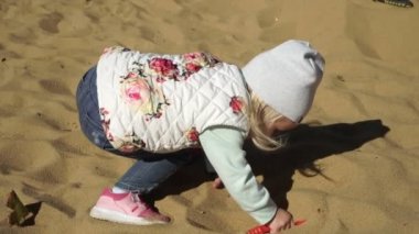 Küçük bir çocuk kum havuzunda oynuyor. Çocukluk, eğlenceli.