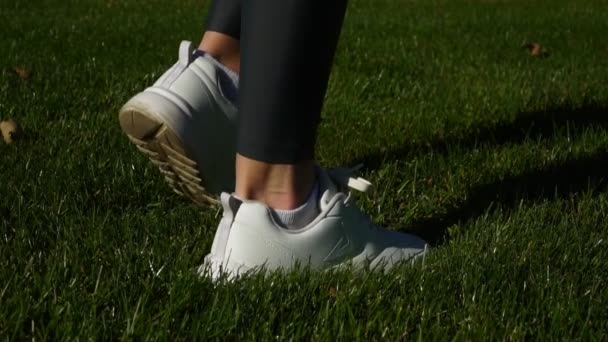 女性のスニーカー。緑の芝生にフィットネスを行う女性. — ストック動画