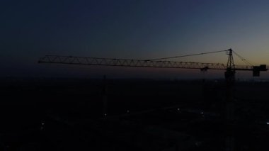Dawn, alacakaranlık, bir inşaat vinç silüeti.