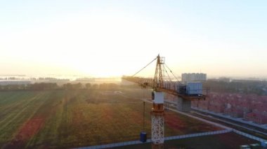 Vinç güneşin şafağı arka plan üzerinde bina.