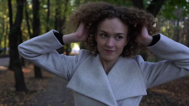 Herfst, jonge mooie vrouw met krullend haar buitenshuis. Slow motion. — Stockvideo