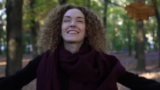 Genç kadın parkta sonbahar yaprakları, yavaş atar. — Stok video