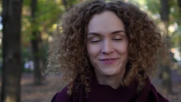 Portrait d'une jeune femme aux cheveux bouclés en plein air. — Video