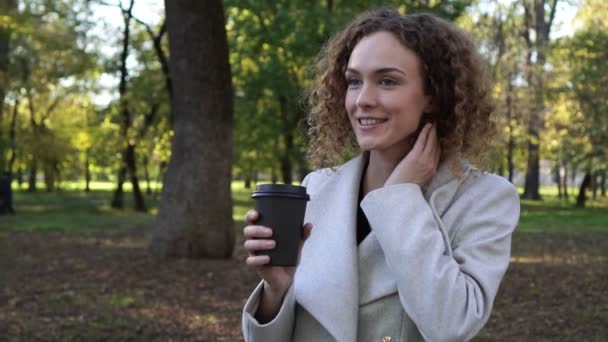 Höst, ultrarapid, ung kvinna dricker kaffe i parken. — Stockvideo