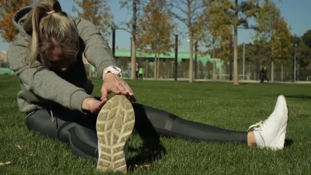 Joven atleta haciendo calentamiento en el parque . — Vídeos de Stock