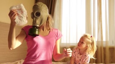 Bir gaz maskesi kirli bebek bezi ile bir kadında.