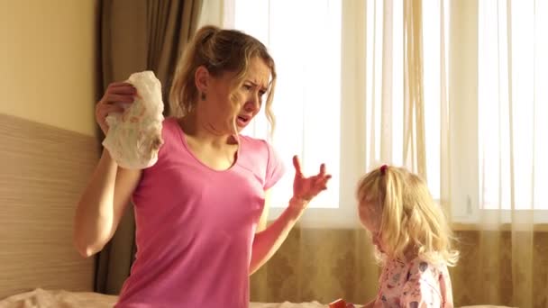 La mujer con disgusto sosteniendo un pañal de bebé sucio. Maternidad, humor . — Vídeo de stock