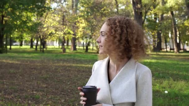 Φθινόπωρο, επιχειρηματική γυναίκα που πίνει καφέ στο πάρκο. — Αρχείο Βίντεο