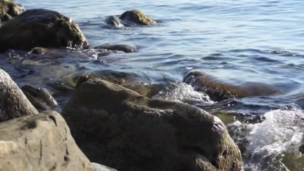 Langsom bevegelse, surf, tidevann, sjøbølger som slår mot klippene på land . – stockvideo