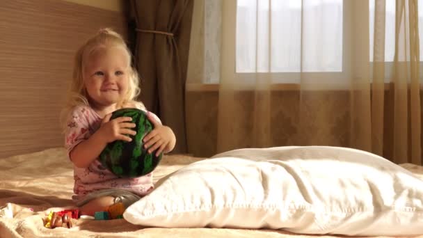 Девочка играет на кровати в спальне . — стоковое видео