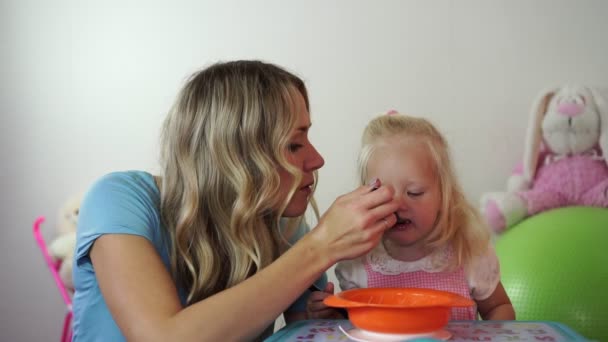 Mãe alimenta mingau de cereal bebê com uma colher . — Vídeo de Stock