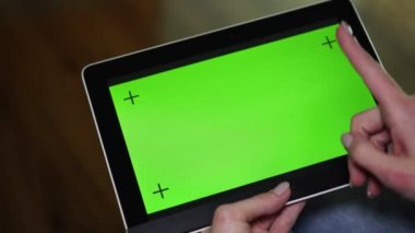 Yeşil bir ekran ile bir tablet bilgisayarda el hareketleri bir kadın yapar.