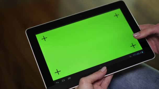 Uma mulher usa um computador tablet com uma tela verde . — Vídeo de Stock