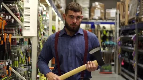 Um homem com um machado numa loja de ferragens . — Vídeo de Stock