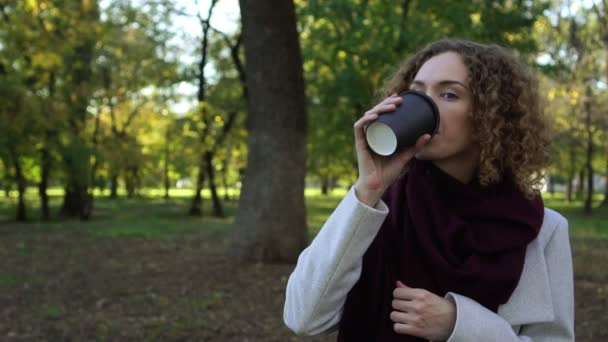 Mujer de negocios bebe café en el parque de tazas de papel . — Vídeo de stock