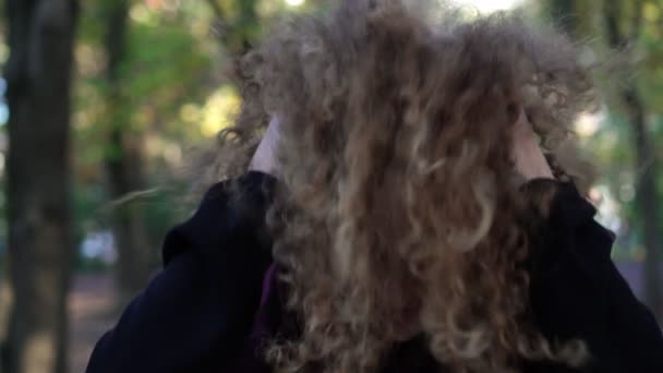 Молодая женщина трясет кудрявые волосы, замедленная съемка . — стоковое видео