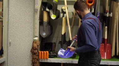 Sakallı bir adam, bir çiftçi donanım mağazasında.