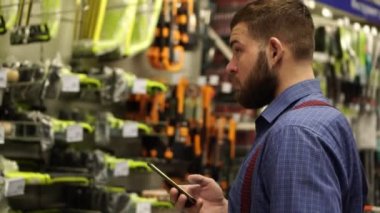 Acımasız adam ile bir smartphone bir donanım mağaza.