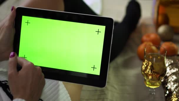 Donna che tiene tablet con display verde vuoto sullo sfondo di Natale . — Video Stock