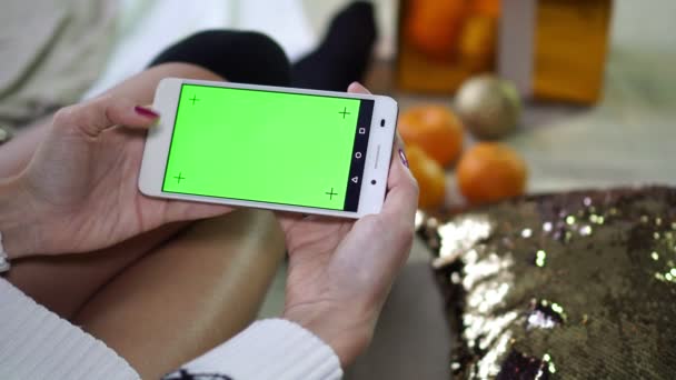 El concepto de Navidad. Mujer sosteniendo smartphone con pantalla verde . — Vídeo de stock