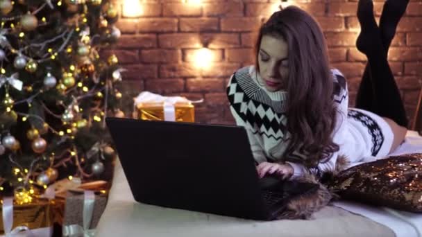 Jovem com laptop no fundo da árvore de Natal . — Vídeo de Stock