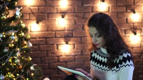 Young woman with tablet on Christmas or new year background. — Stock Video