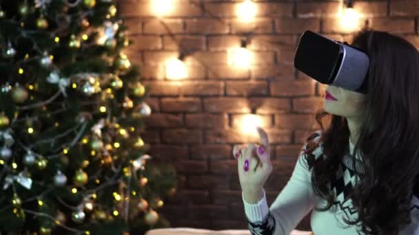 Uma jovem mulher de óculos VR faz gestos com as mãos. Ano Novo e Natal . — Vídeo de Stock