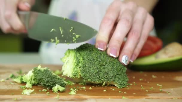 Женщина режет брокколи на кухне, замедленная съемка . — стоковое видео