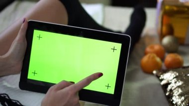 Bir kadın bir tablet ile boş bir yeşil ekran kullanır..