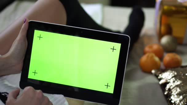 A tablet computer with a clean green screen in the hands of a woman. — Stock Video